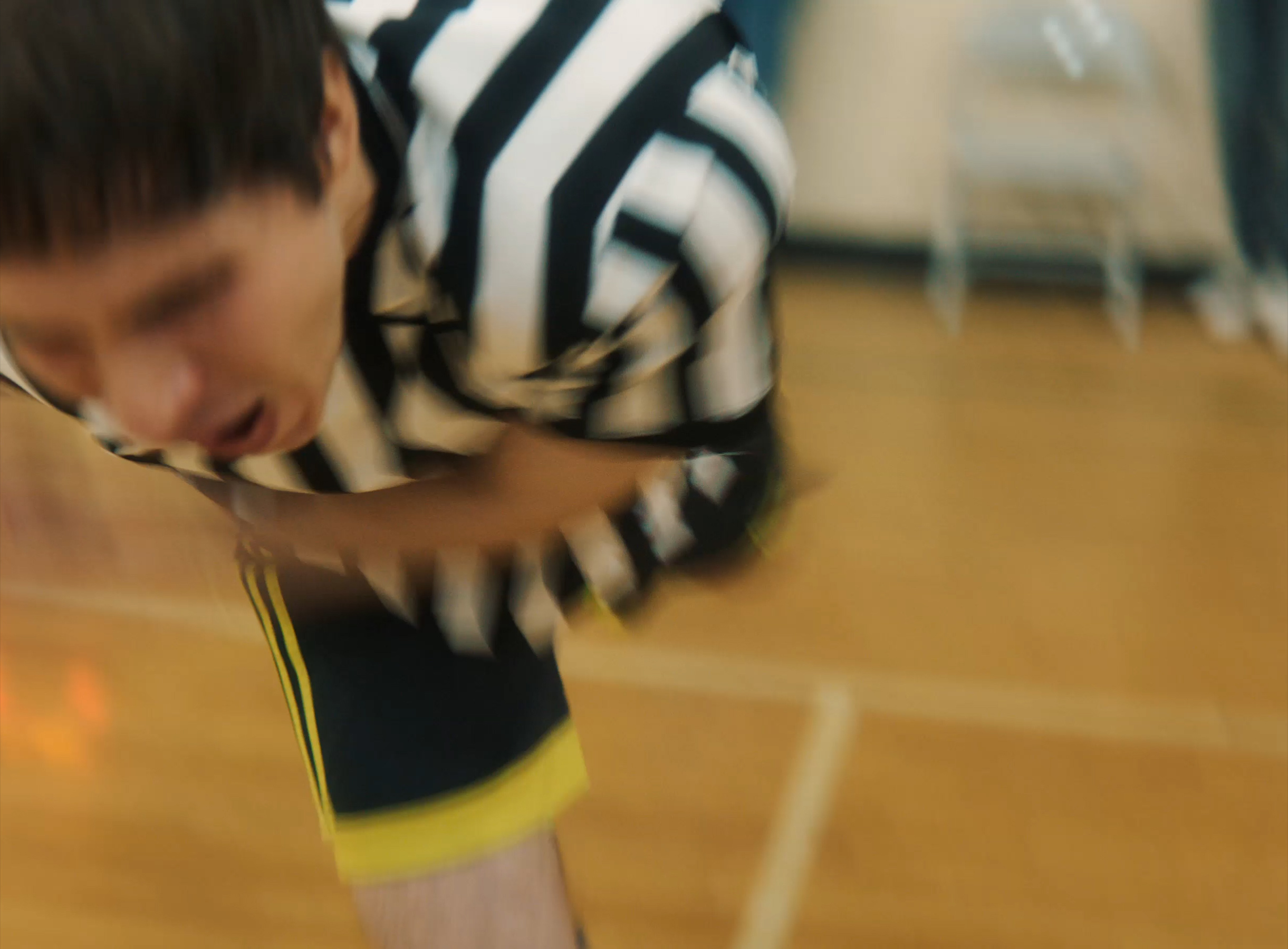 Key art for The Ref (2021), showing a referee in a striped jersey amid a chaotic youth basketball game.